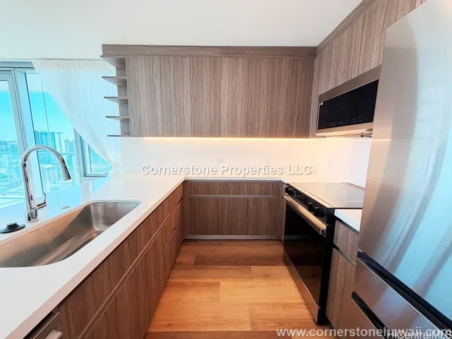 a kitchen with stainless steel appliances kitchen island wooden cabinets a fireplace and a sink