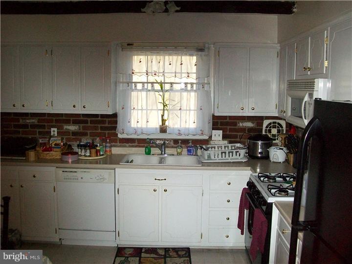 449 Doe Run Lane Springfield, PA 19064 - Photo 6 of 11 a kitchen with stainless steel appliances granite countertop a stove a sink dishwasher and a refrigerator
