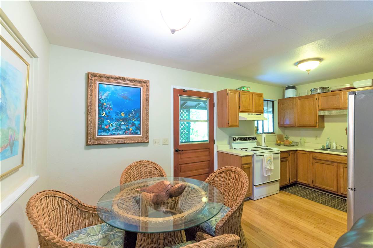 4025 Lower Honoapiilani Road Lahaina, HI 96761 - Photo 18 of 21 a kitchen with stainless steel appliances granite countertop a stove a sink a dining table and chairs