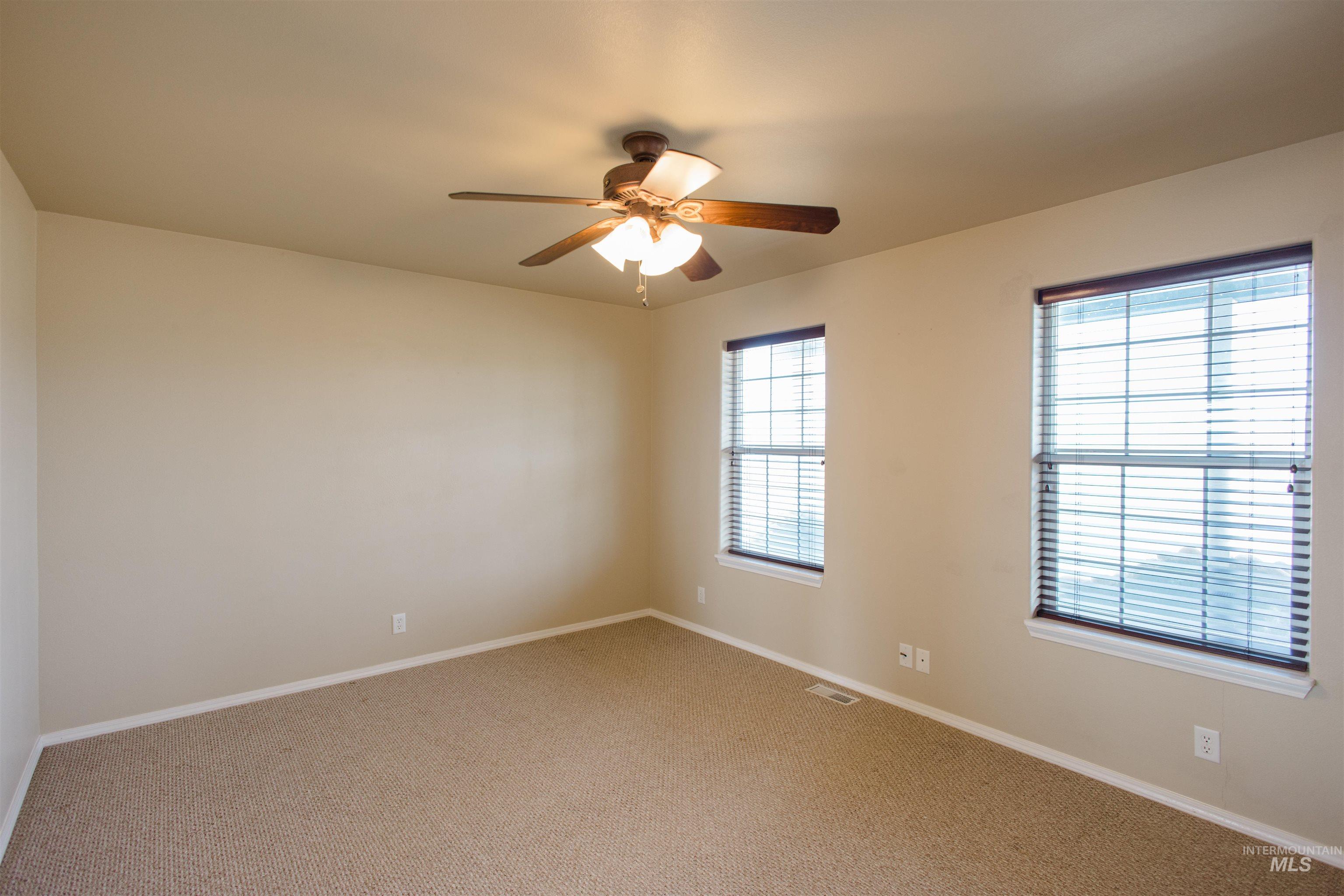 1571 Southeast Hamilton Road Mountain Home, ID 83647 - Photo 9 of 50 Carpeted empty room featuring baseboards and a ceiling fan