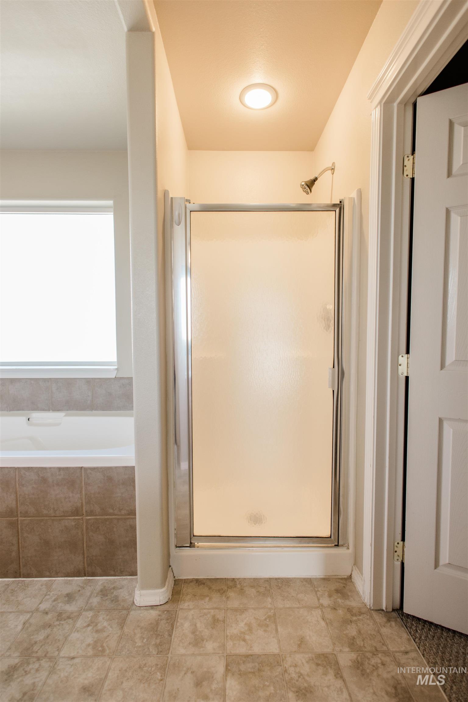 1571 Southeast Hamilton Road Mountain Home, ID 83647 - Photo 20 of 50 Full bathroom with a stall shower and a garden tub