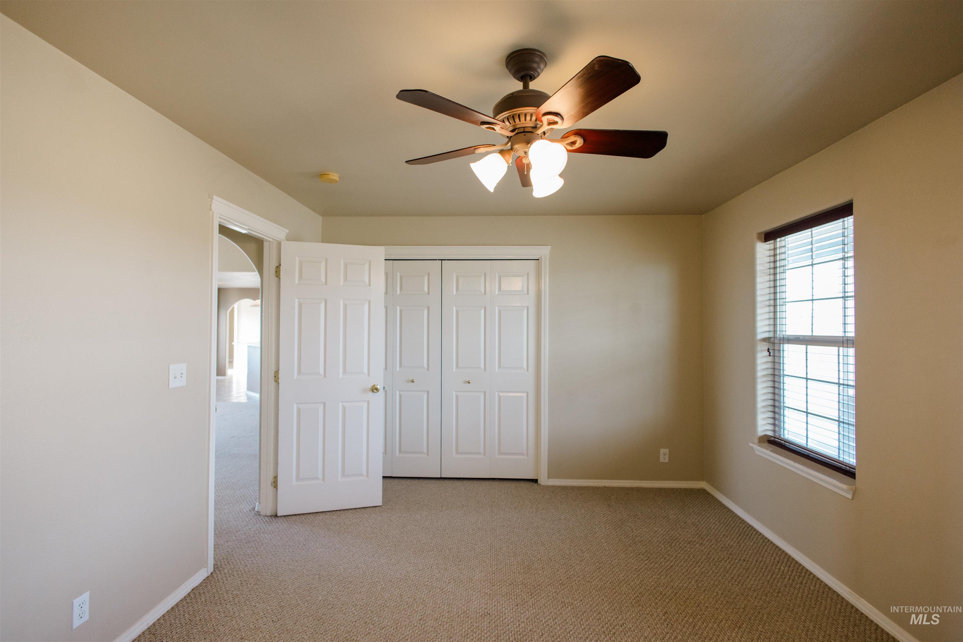 1571 Southeast Hamilton Road Mountain Home, ID 83647 - Photo 24 of 50 Unfurnished bedroom with light carpet, arched walkways, ceiling fan, and a closet