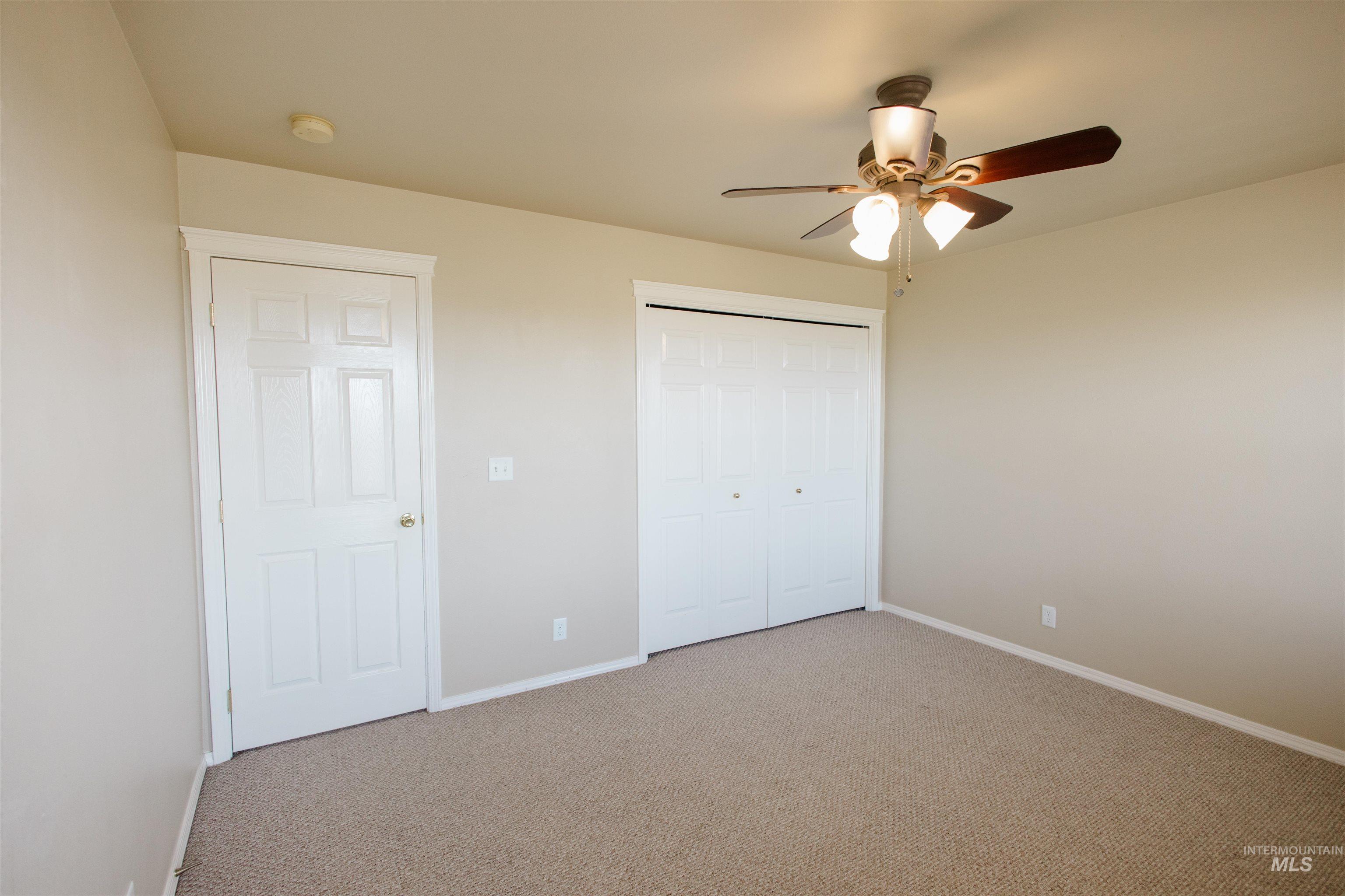 1571 Southeast Hamilton Road Mountain Home, ID 83647 - Photo 28 of 50 Unfurnished bedroom featuring carpet, a ceiling fan, and a closet