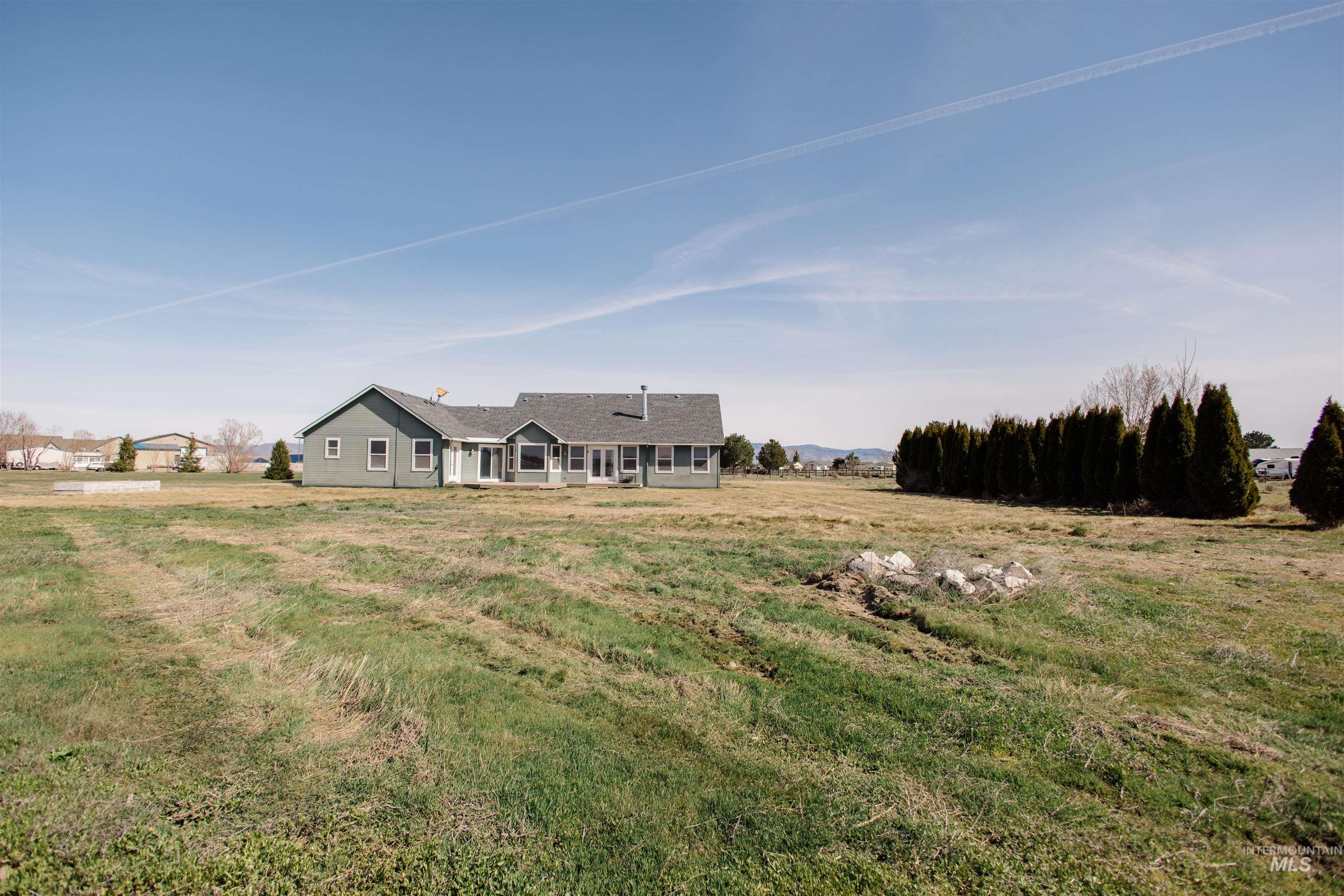 1571 Southeast Hamilton Road Mountain Home, ID 83647 - Photo 40 of 50 View of front of home featuring a front lawn, a patio, and a view of rural / pastoral area