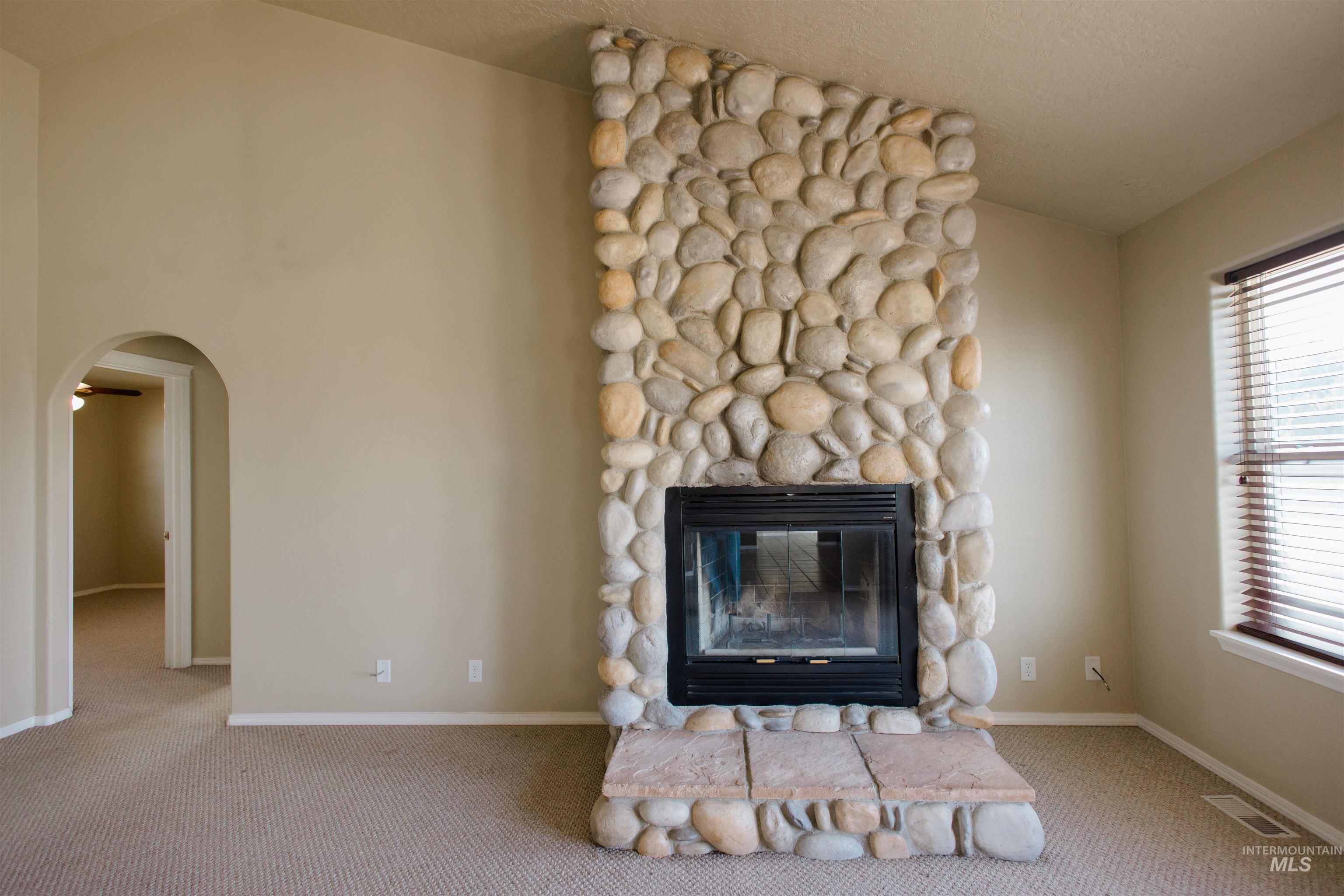 1571 Southeast Hamilton Road Mountain Home, ID 83647 - Photo 6 of 50 Detailed view of carpet flooring, arched walkways, and a fireplace