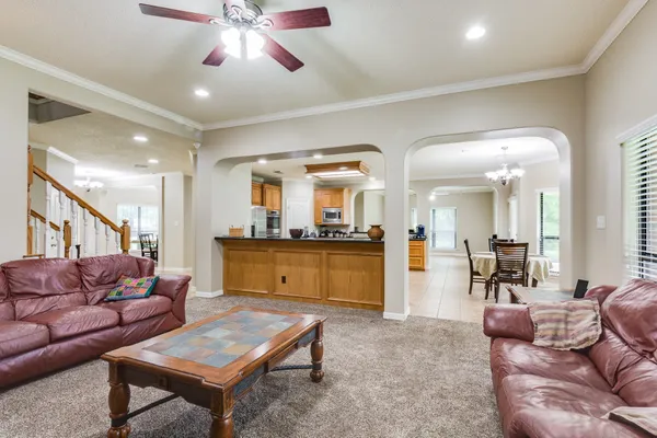 a living room with furniture and a view of kitchen
