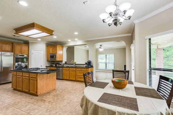 a large kitchen with a counter space a sink appliances and living room view