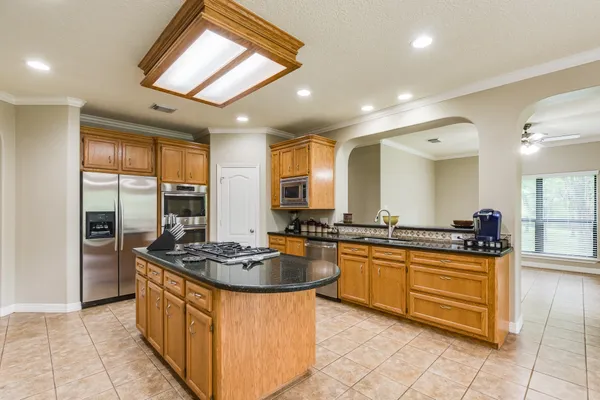 a kitchen with stainless steel appliances granite countertop a stove a sink dishwasher and a refrigerator