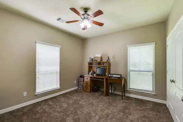 a view of a workspace with furniture and a window