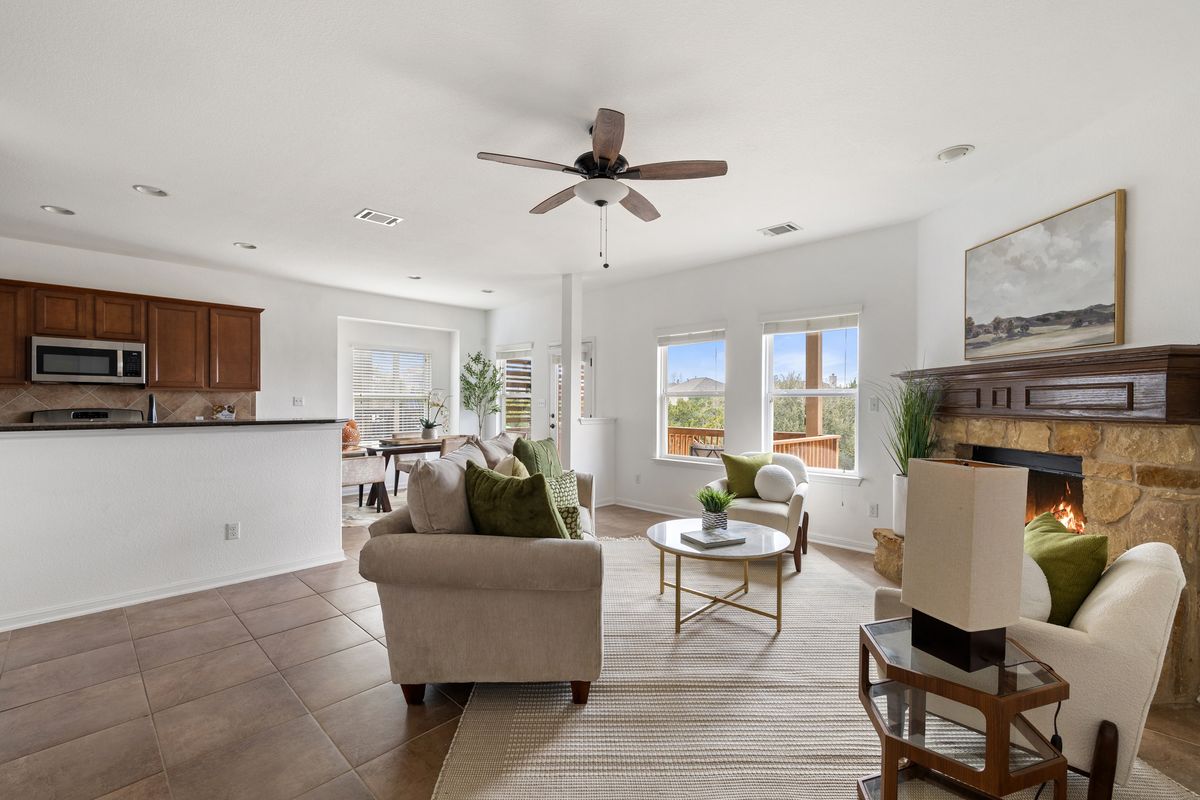 407 Stone View Trail Austin, TX 78737 - Photo 11 of 40 a living room with furniture a fireplace and a ceiling fan