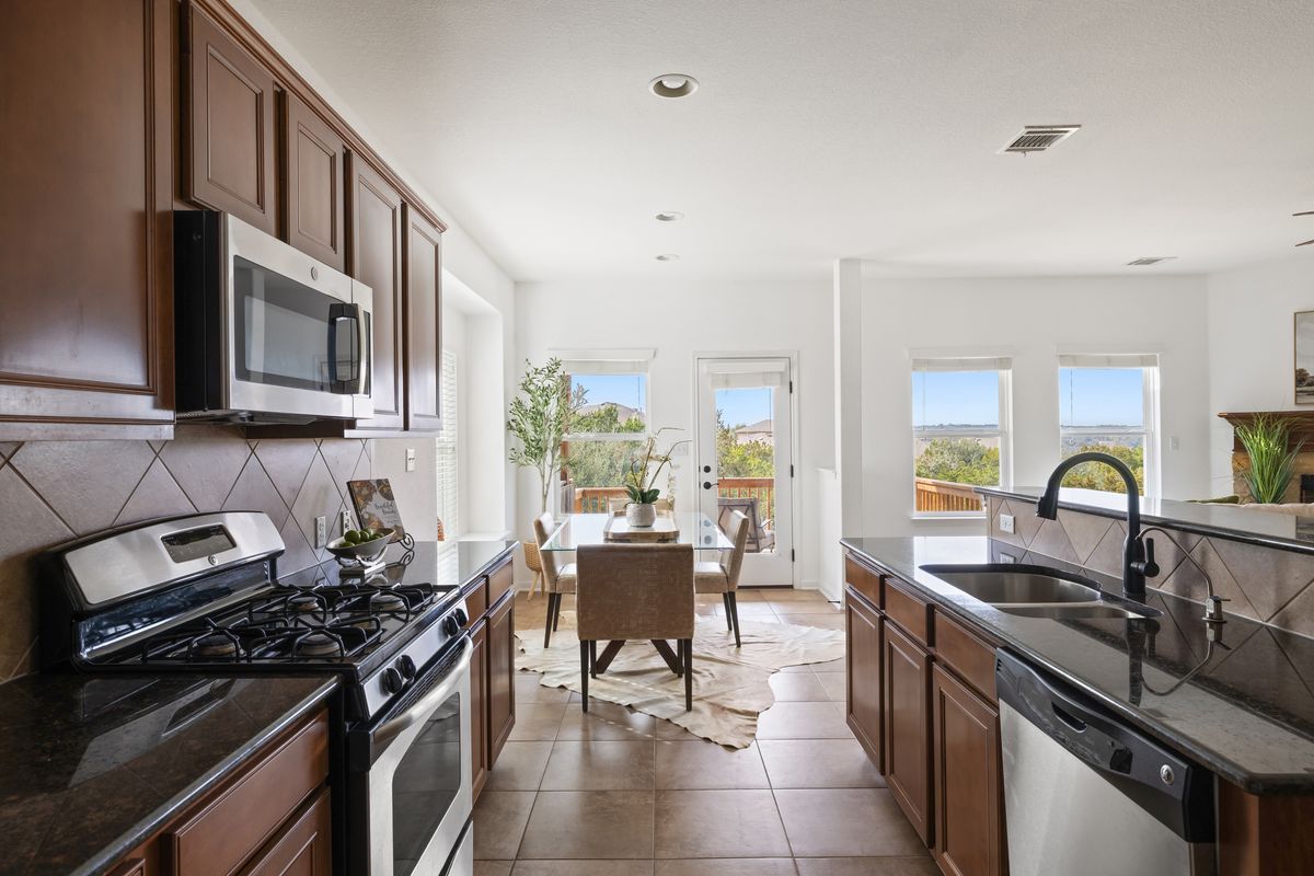 407 Stone View Trail Austin, TX 78737 - Photo 15 of 40 a kitchen with stainless steel appliances a stove sink microwave and cabinets