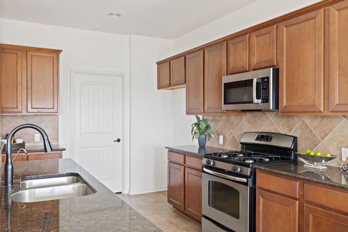 407 Stone View Trail Austin, TX 78737 - Photo 17 of 40 a kitchen with appliances a sink and cabinets