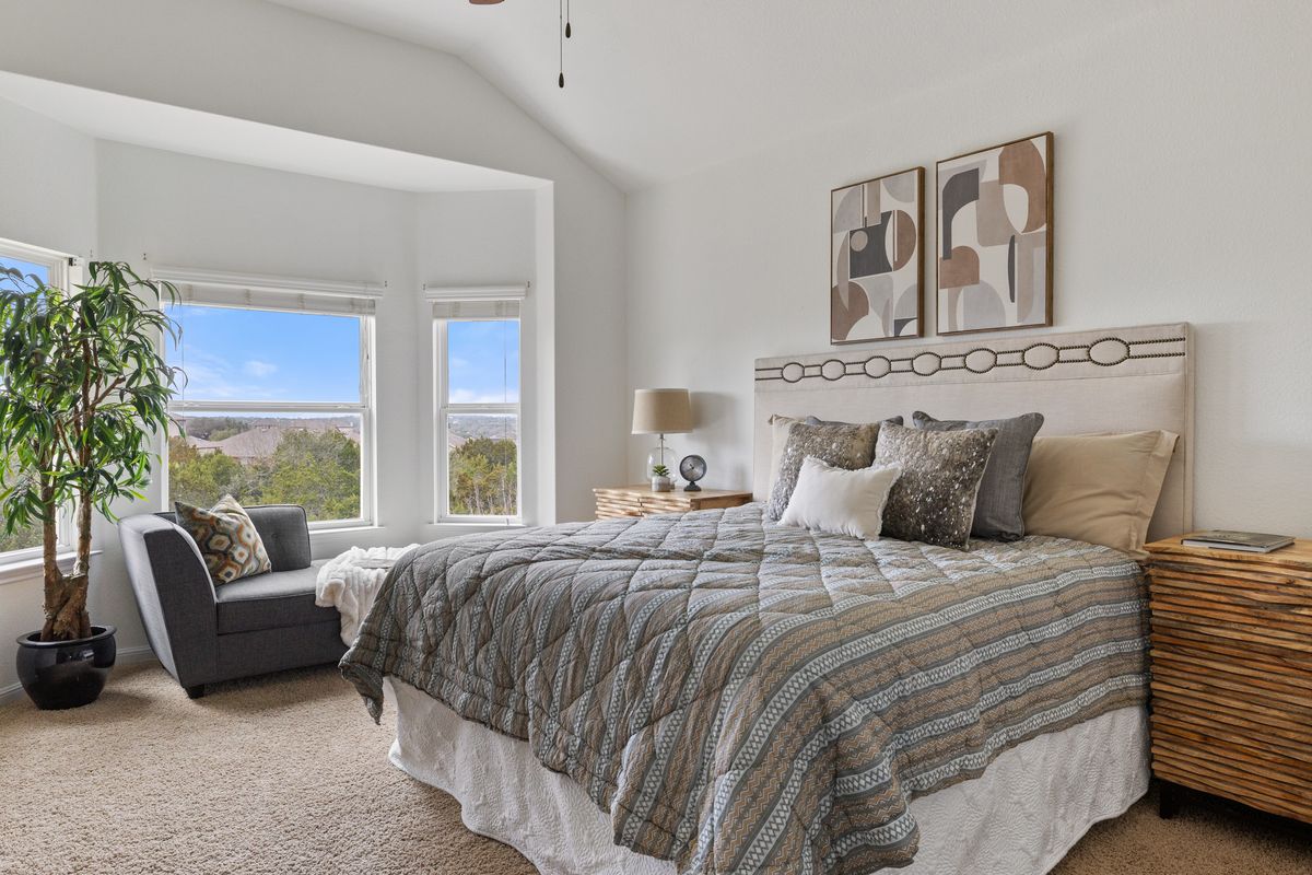 407 Stone View Trail Austin, TX 78737 - Photo 22 of 40 a bedroom with a large bed couch and a large window