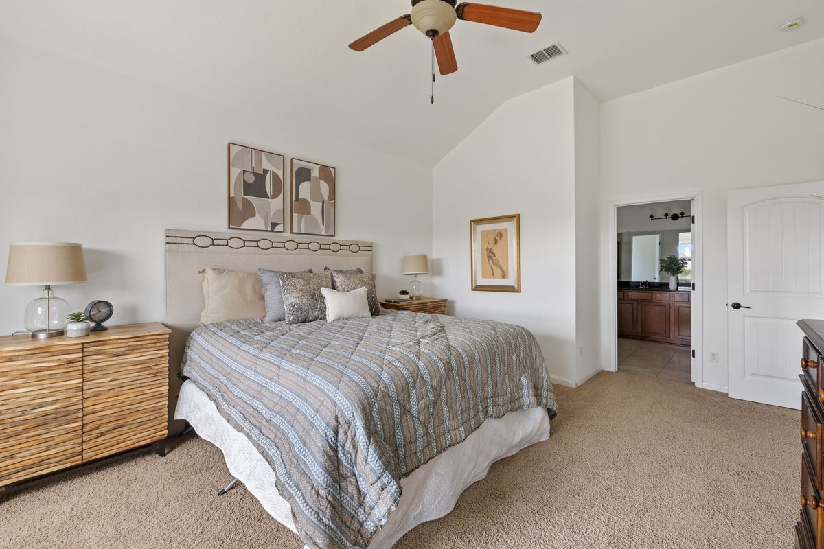 407 Stone View Trail Austin, TX 78737 - Photo 23 of 40 a bedroom with a bed and a chandelier
