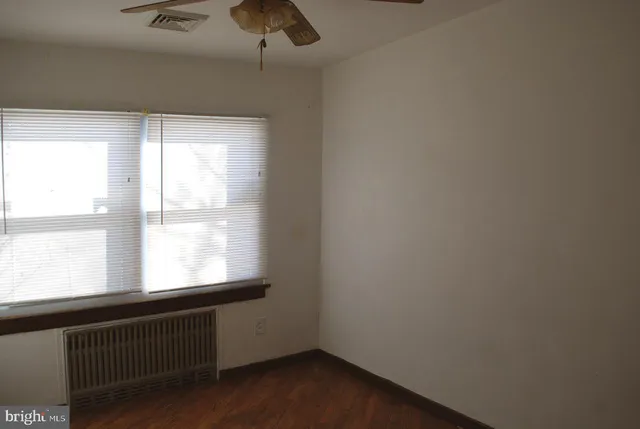 an empty room with wooden floor & closet