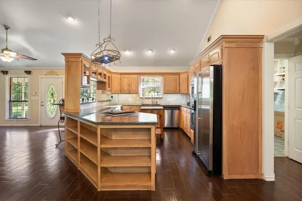 a kitchen with stainless steel appliances a refrigerator and a view of living room