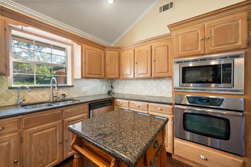 7410 County Road Kerens, TX 75144 - Photo 14 of 35 a kitchen with granite countertop a sink stove and microwave