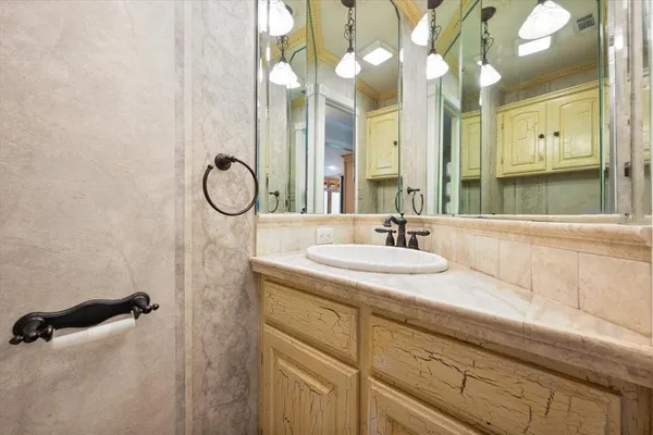 a bathroom with a granite countertop sink a mirror and a shower