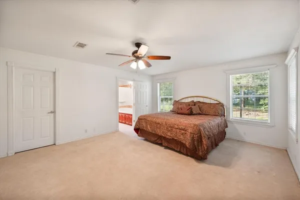 a spacious bedroom with a bed and a ceiling fan