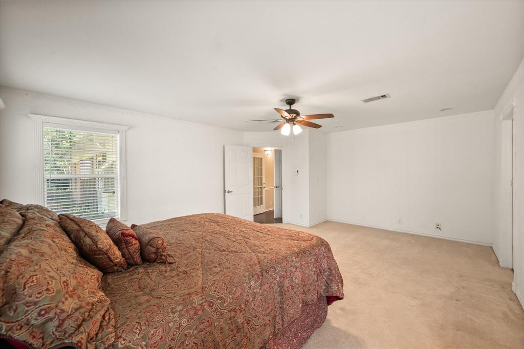 7410 County Road Kerens, TX 75144 - Photo 25 of 35 a large bed sitting in a bedroom next to a window and a chandelier