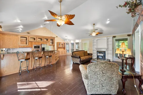 a living room with furniture a dining table and chairs to ceiling window with wooden floor