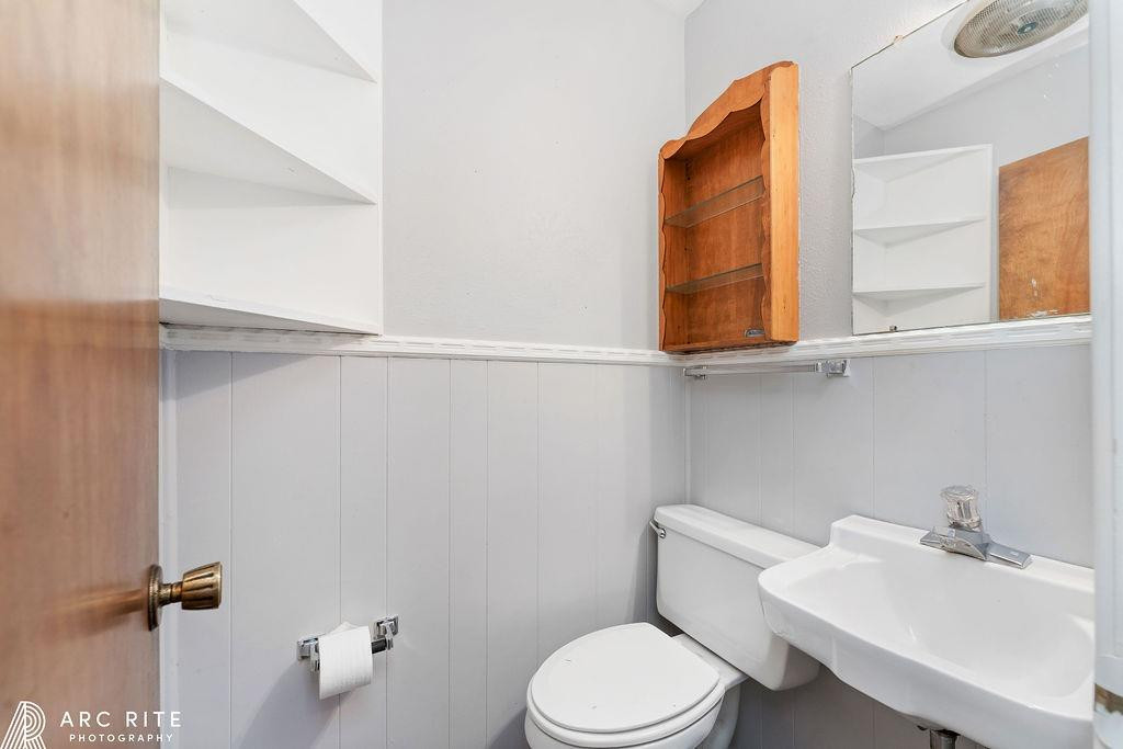 2123 North Cypress Road Lubbock, TX 79403 - Photo 16 of 22 a white toilet sitting next to a bathroom sink