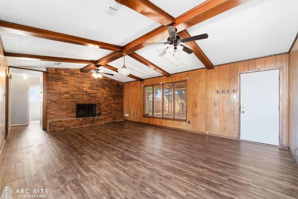 2123 North Cypress Road Lubbock, TX 79403 - Photo 4 of 22 a view of an empty room with wooden floor fireplace and a window