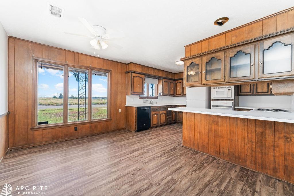 2123 North Cypress Road Lubbock, TX 79403 - Photo 6 of 22 a large white kitchen with stainless steel appliances granite countertop a sink and wooden floors