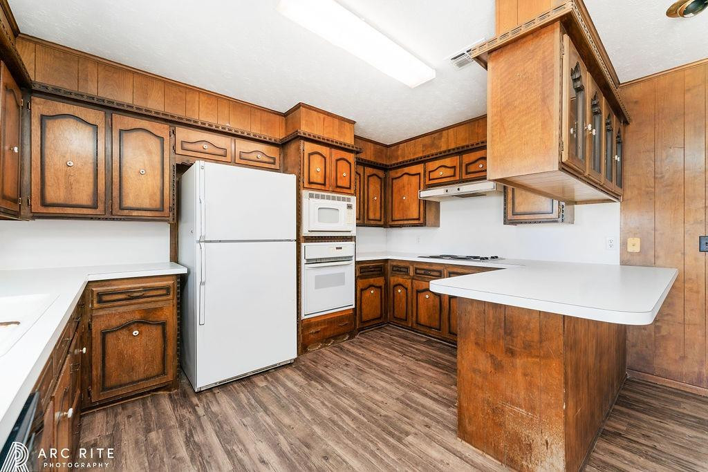 2123 North Cypress Road Lubbock, TX 79403 - Photo 8 of 22 a kitchen with stainless steel appliances granite countertop a refrigerator a stove and a sink with wooden floors