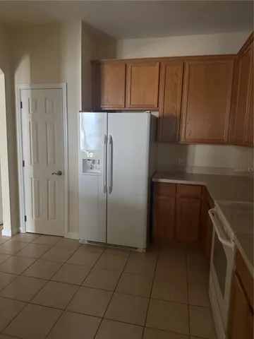 a kitchen with a refrigerator sink and cabinets