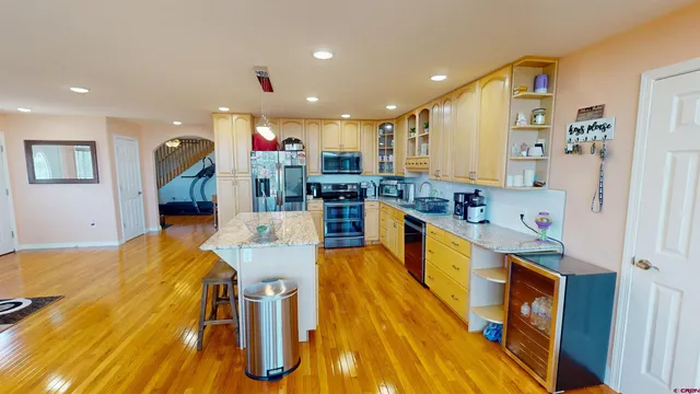 a kitchen with stainless steel appliances kitchen island granite countertop a table and chairs in it