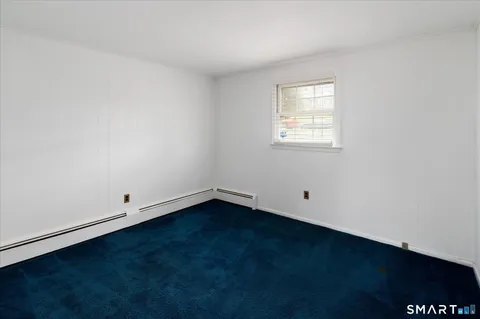 an empty room with a hard wood floor and a window