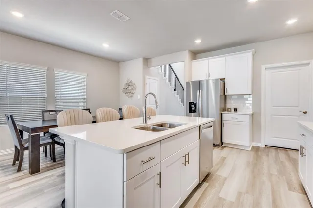 a kitchen with a sink a stove a refrigerator and cabinets