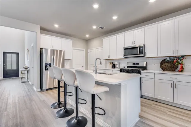 a kitchen with a refrigerator a stove a sink and a cabinets