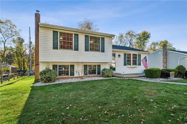 a front view of a house with a yard and trees