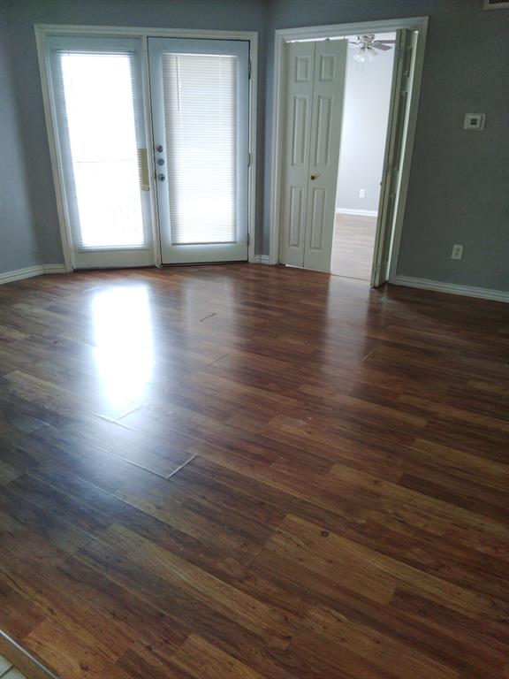 9809 Walnut Street, Unit E305 Dallas, TX 75243 - Photo 1 of 16 Spare room featuring dark wood finished floors and ceiling fan