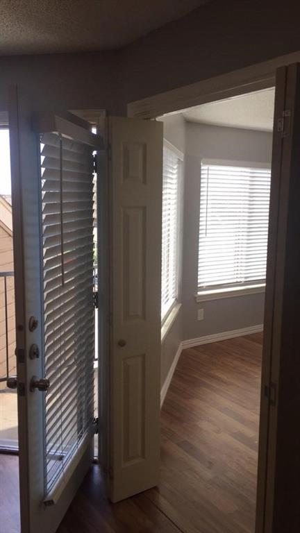 9809 Walnut Street, Unit E305 Dallas, TX 75243 - Photo 8 of 16 Entrance foyer featuring plenty of natural light, dark wood finished floors, and a textured ceiling
