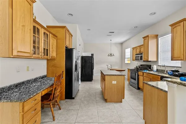 a kitchen with stainless steel appliances granite countertop a stove top oven a refrigerator a sink and dishwasher