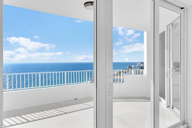 a kitchen with stainless steel appliances kitchen island granite countertop a refrigerator a sink and white cabinets