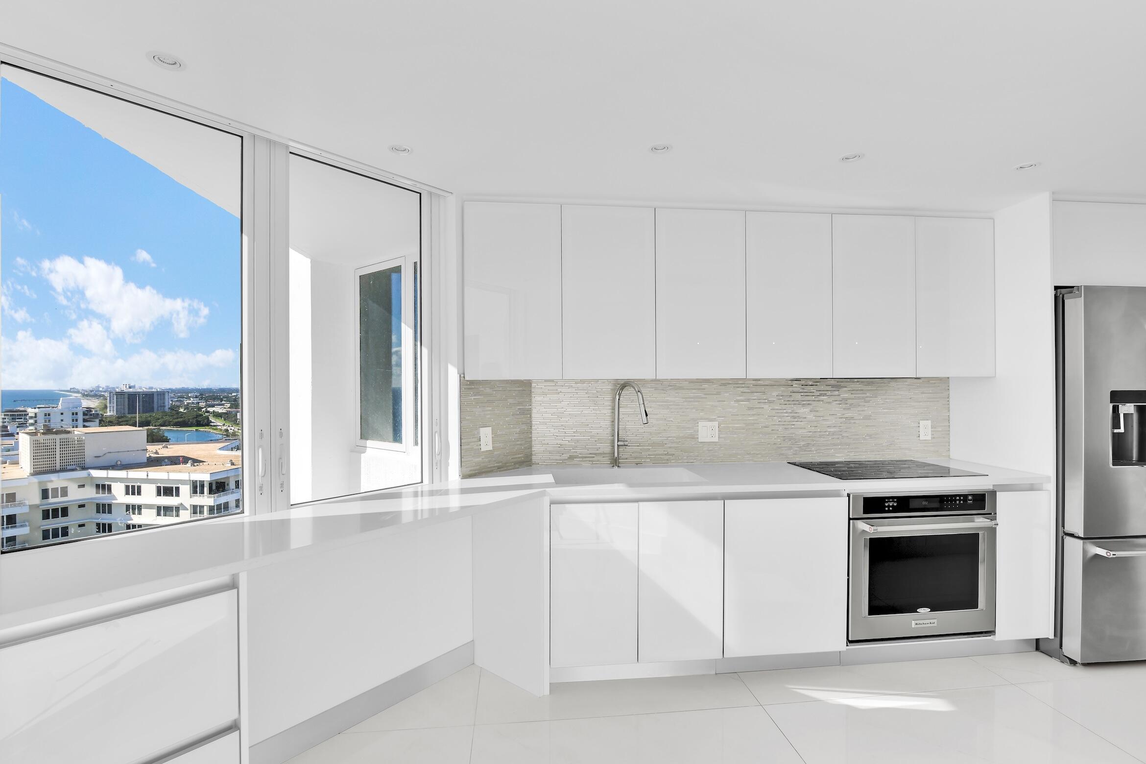 550 South Ocean Boulevard, Unit PH06 Boca Raton, FL 33432 - Photo 14 of 62 a kitchen with white cabinets and appliances