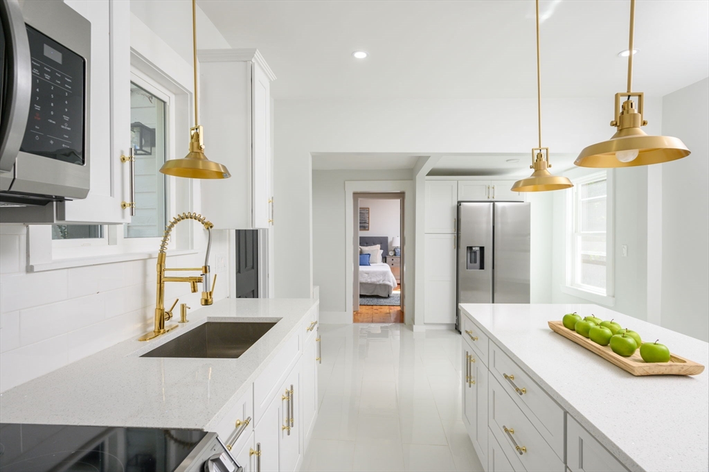 120 Broadway Hanover, MA 02339 - Photo 9 of 35 a kitchen with a sink a stove and cabinets