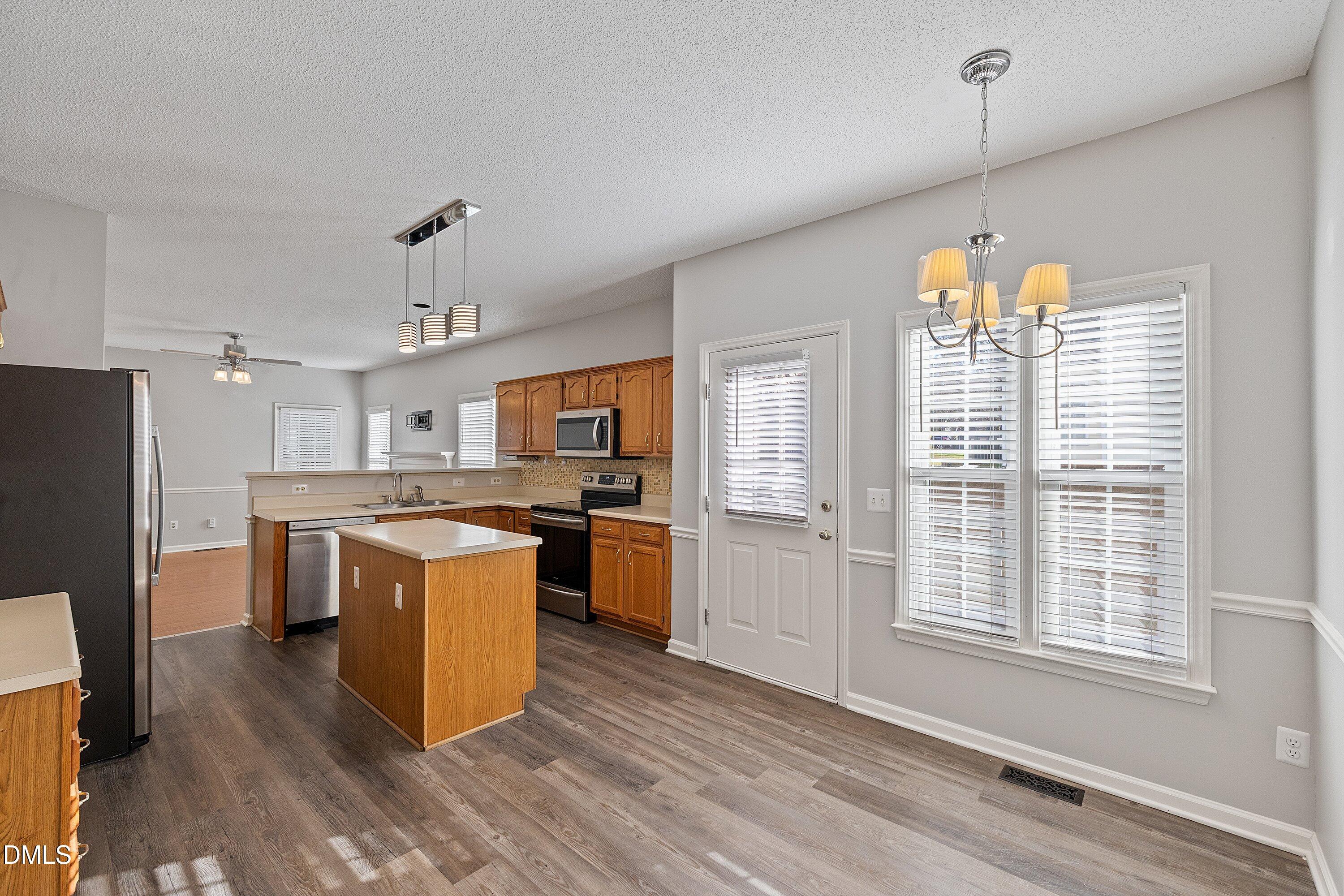 113 Laurel Branch Drive Cary, NC 27513 - Photo 15 of 40 a kitchen with kitchen island granite countertop a sink cabinets and wooden floor