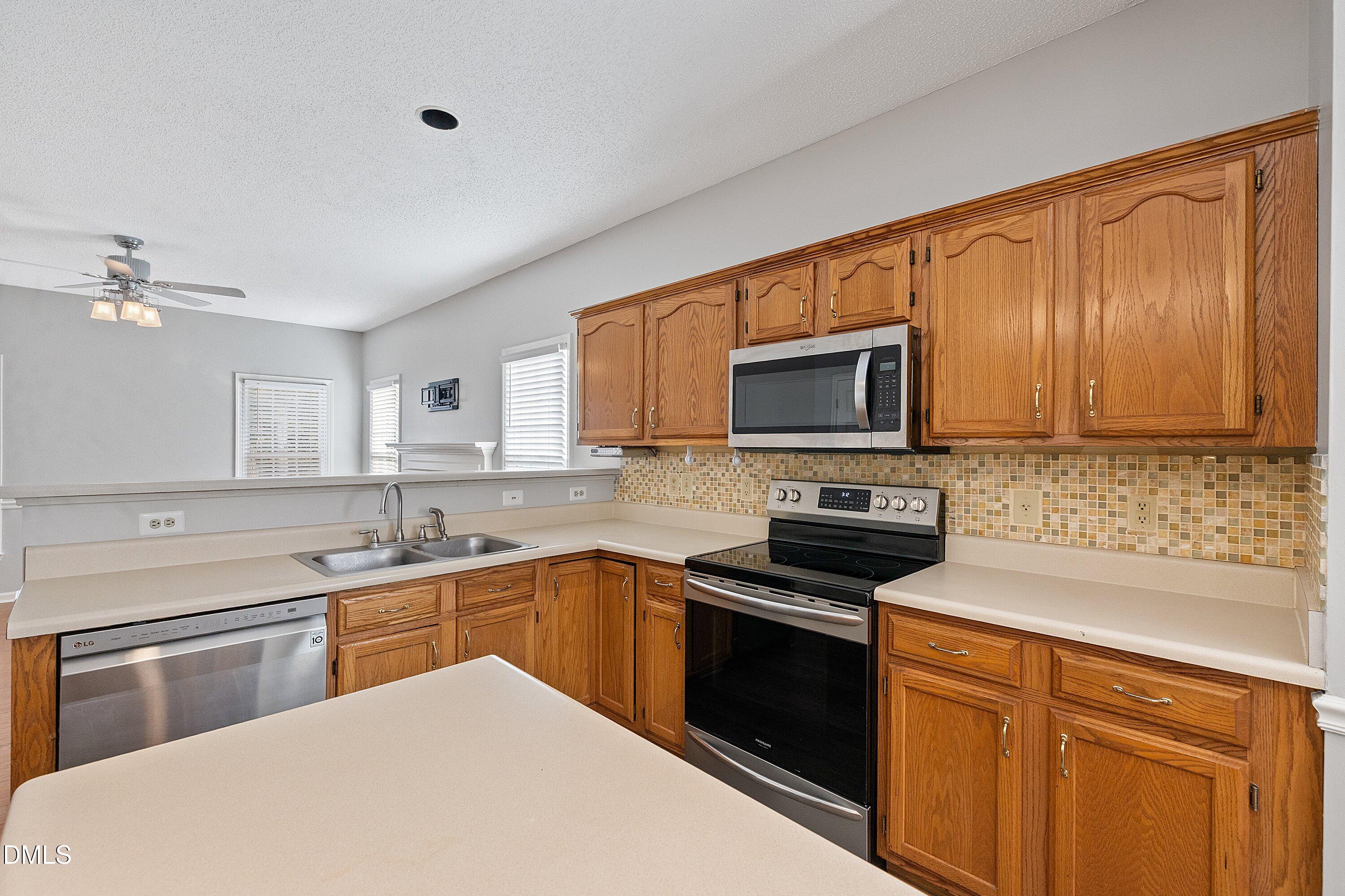 113 Laurel Branch Drive Cary, NC 27513 - Photo 16 of 40 a kitchen with a sink stove and microwave