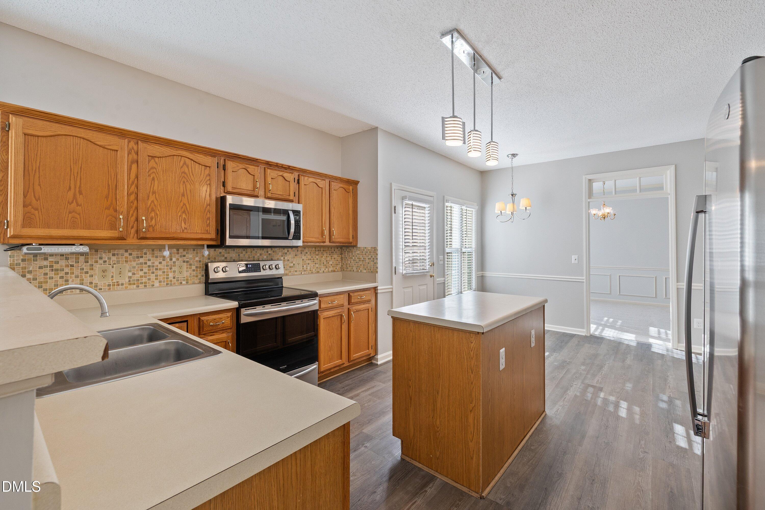 113 Laurel Branch Drive Cary, NC 27513 - Photo 17 of 40 a kitchen with a sink a counter top space stainless steel appliances and cabinets