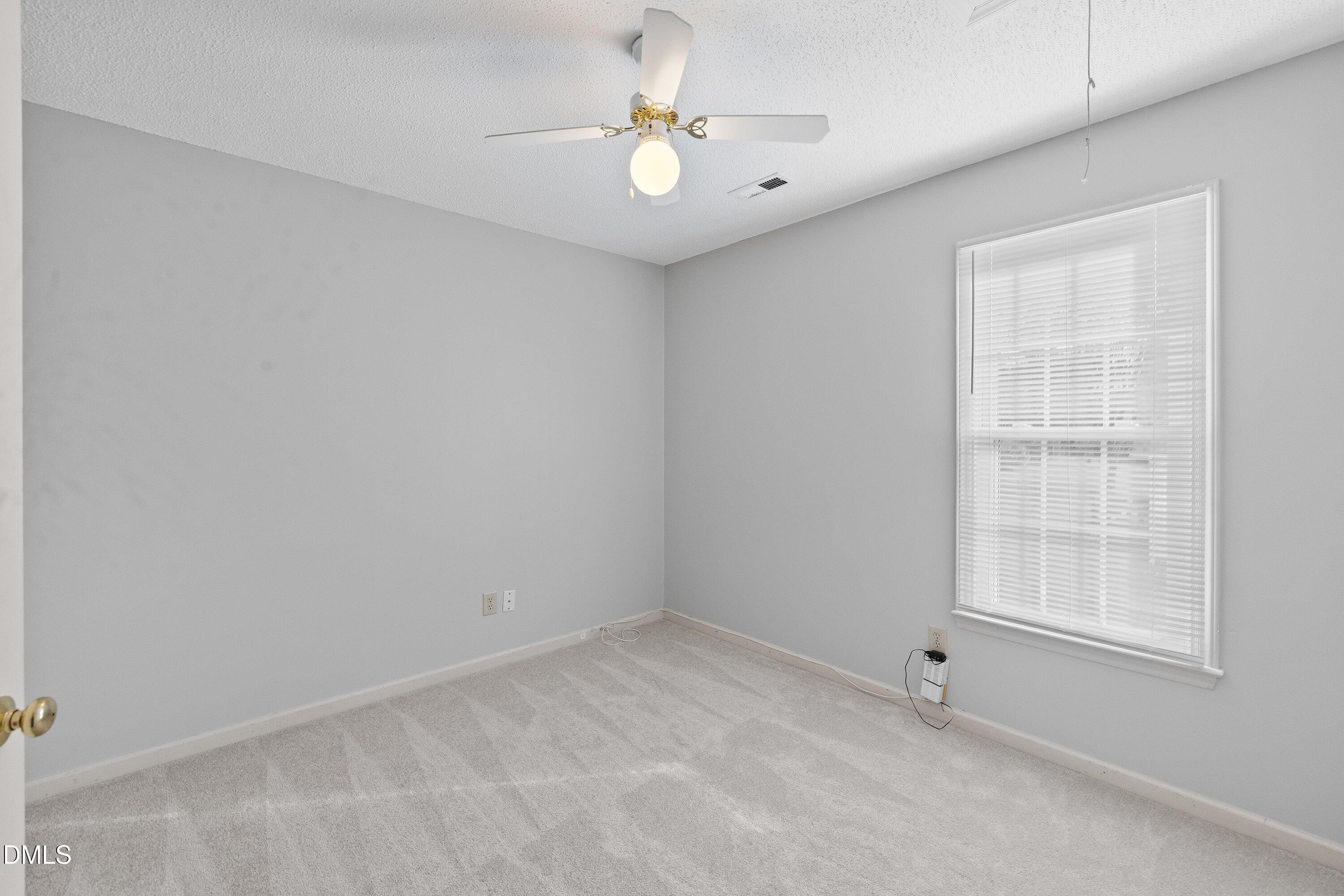 113 Laurel Branch Drive Cary, NC 27513 - Photo 32 of 40 an empty room with chandelier fan and windows