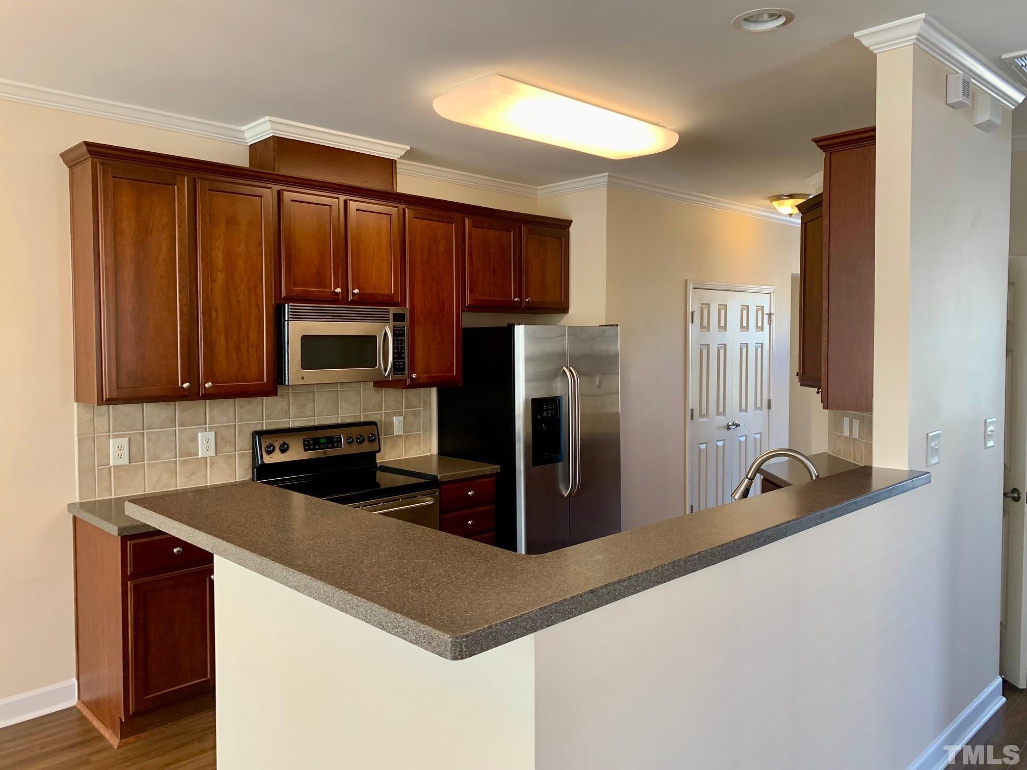 241 Grenoch Valley Lane Apex, NC 27539 - Photo 14 of 27 a kitchen with wooden cabinets and a sink