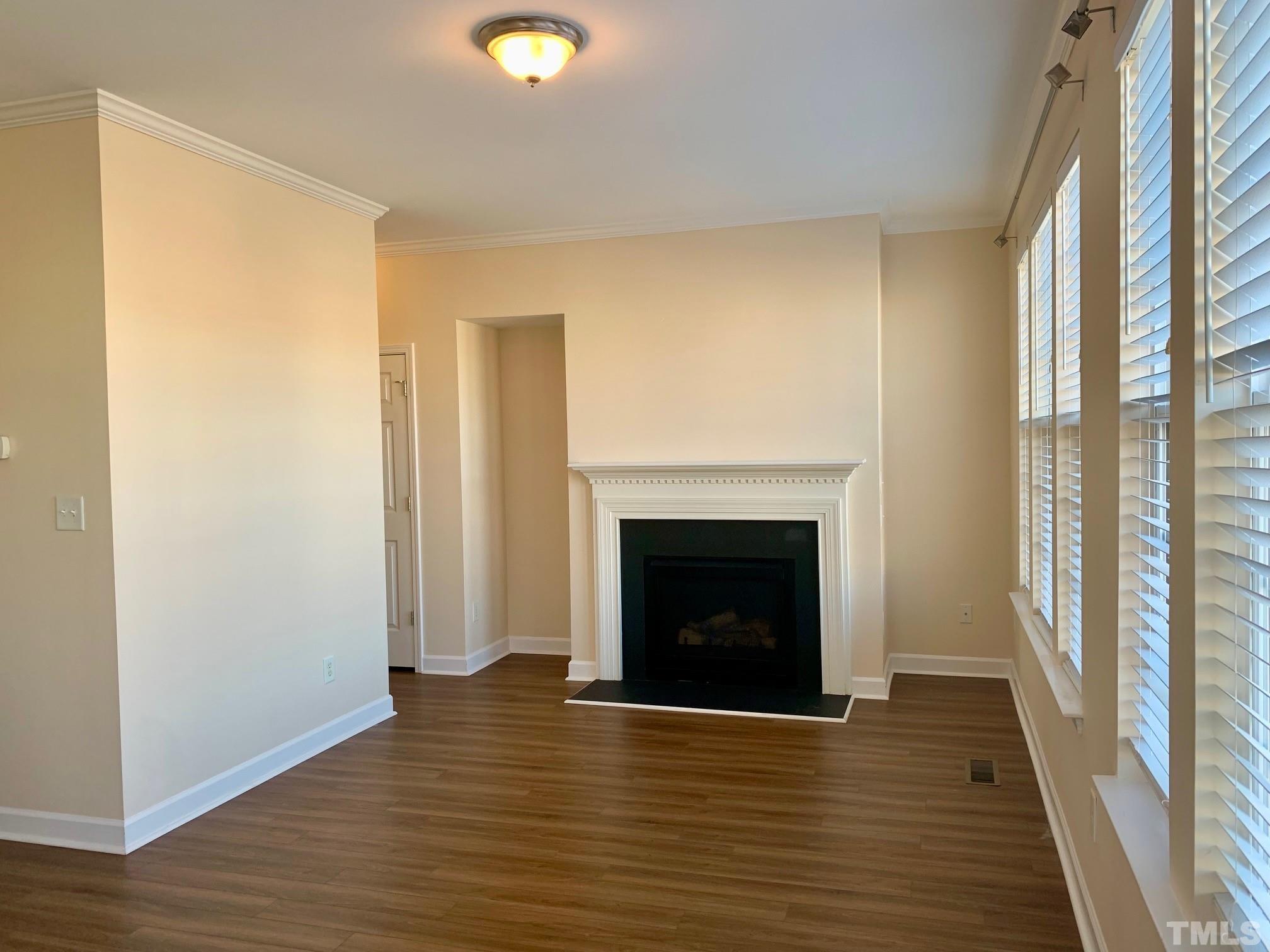 241 Grenoch Valley Lane Apex, NC 27539 - Photo 7 of 27 a view of an empty room with wooden floor and a window