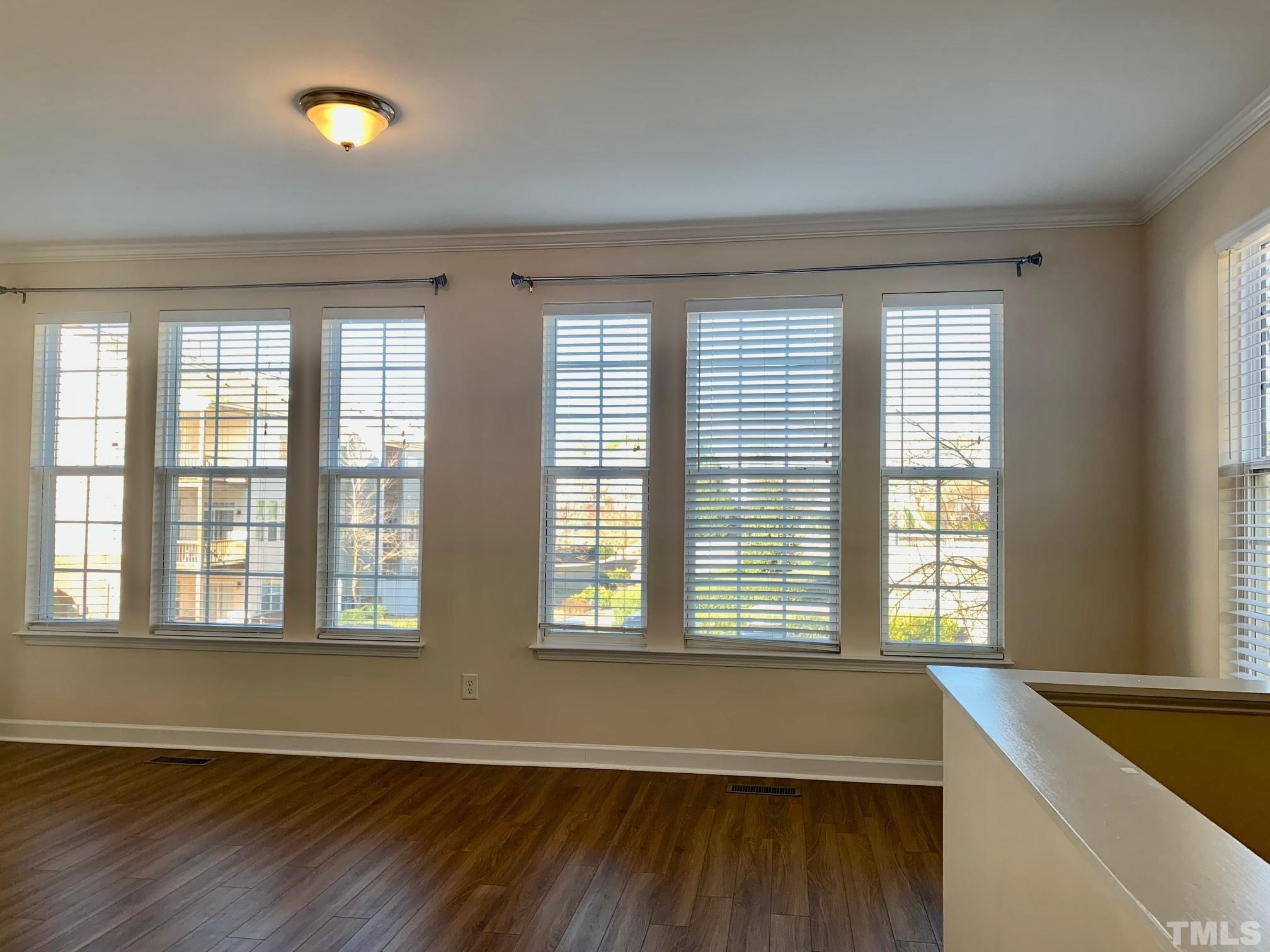 241 Grenoch Valley Lane Apex, NC 27539 - Photo 8 of 27 an empty room with wooden floor and windows