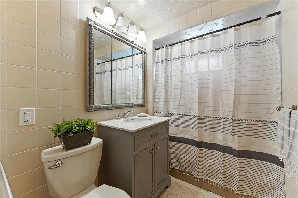 29 Hillcrest Circle, Unit 2 Watertown, MA 02472 - Photo 17 of 36 a bathroom with a sink a toilet a mirror and shower