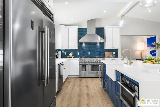 a kitchen with stainless steel appliances granite countertop a stove and a white cabinets